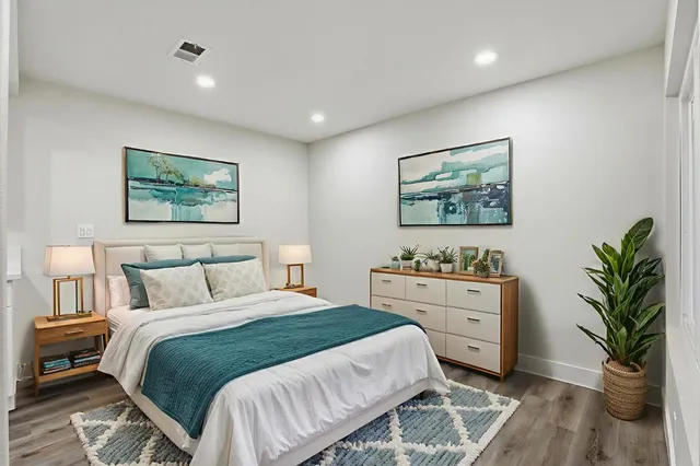 a bedroom with a bed and a painting on the wall