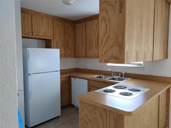 a kitchen with a sink a stove and a refrigerator