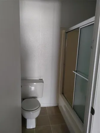 a bathroom with a toilet and a shower