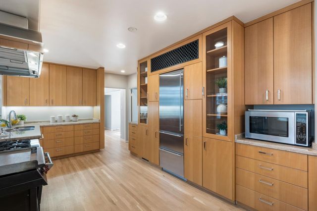 a kitchen with stainless steel appliances kitchen island granite countertop a refrigerator stove and sink