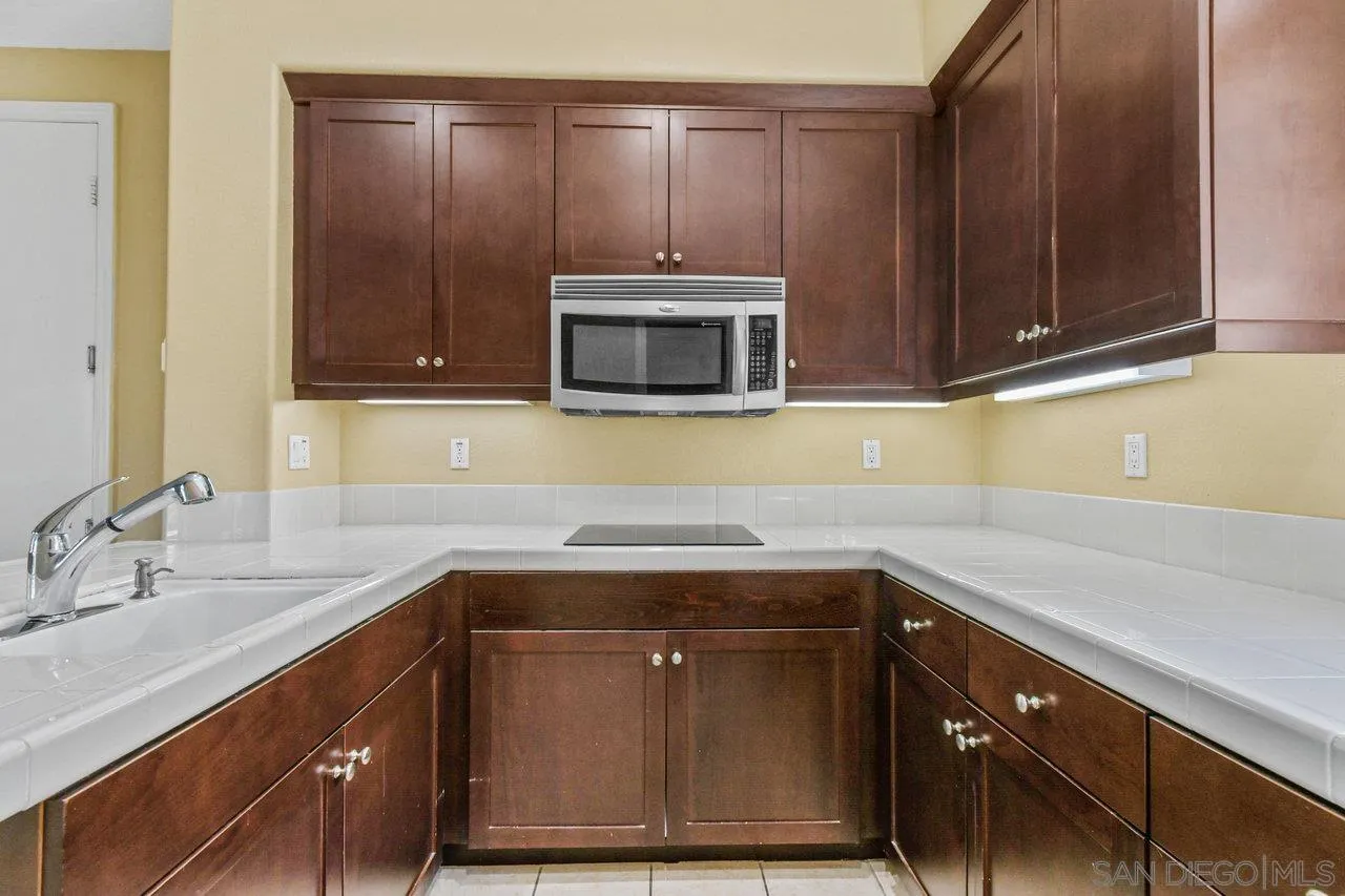 2957 Ranch Gate Road Chula Vista, CA 91914 - Photo 56 of 75 a kitchen with a sink a microwave and cabinets