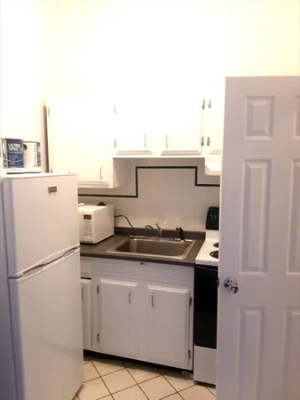 a kitchen with stainless steel appliances granite countertop a refrigerator and a stove