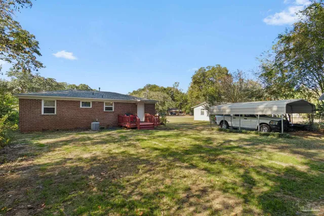 a view of a yard in front of a house with large tree
