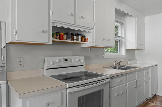 a kitchen with white cabinets and white appliances