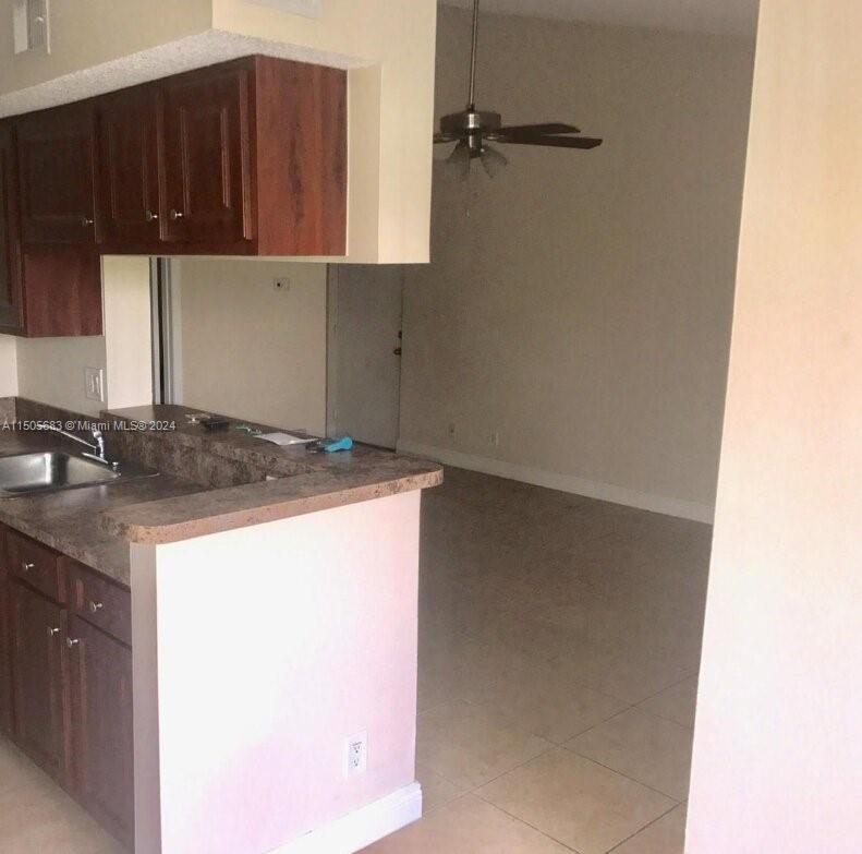 5686 Rock Island Road, Unit 134 Tamarac, FL 33319 - Photo 5 of 21 a kitchen with a sink and cabinets