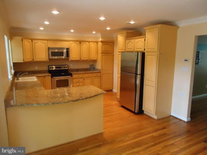 2141 Golf Course Drive Reston, VA 20191 - Photo 9 of 26 a kitchen with stainless steel appliances granite countertop a refrigerator a stove a microwave and a sink