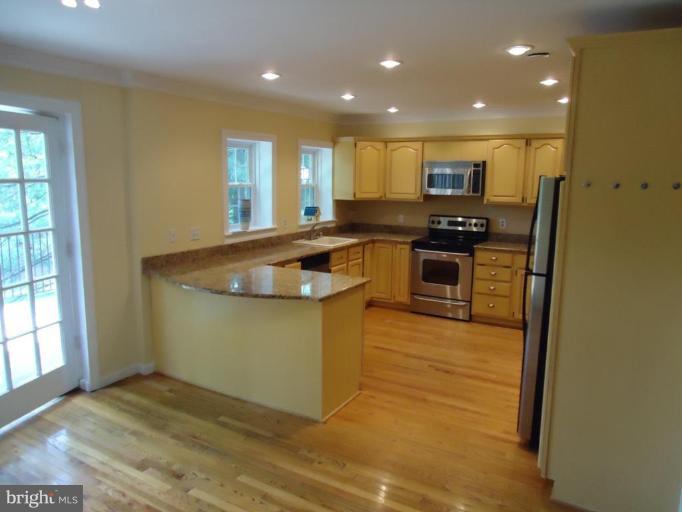 2141 Golf Course Drive Reston, VA 20191 - Photo 10 of 26 a kitchen with stainless steel appliances granite countertop a stove a sink and a refrigerator