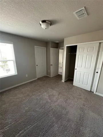 an empty room with a window and a ceiling fan