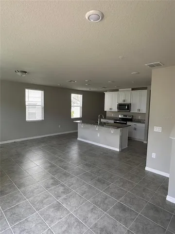 a kitchen with granite countertop a stove a sink and a refrigerator