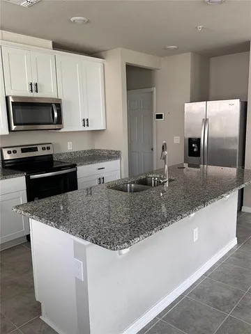 a kitchen with stainless steel appliances granite countertop a sink a stove and granite counter tops