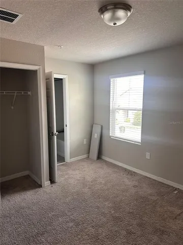 an empty room with windows and closet