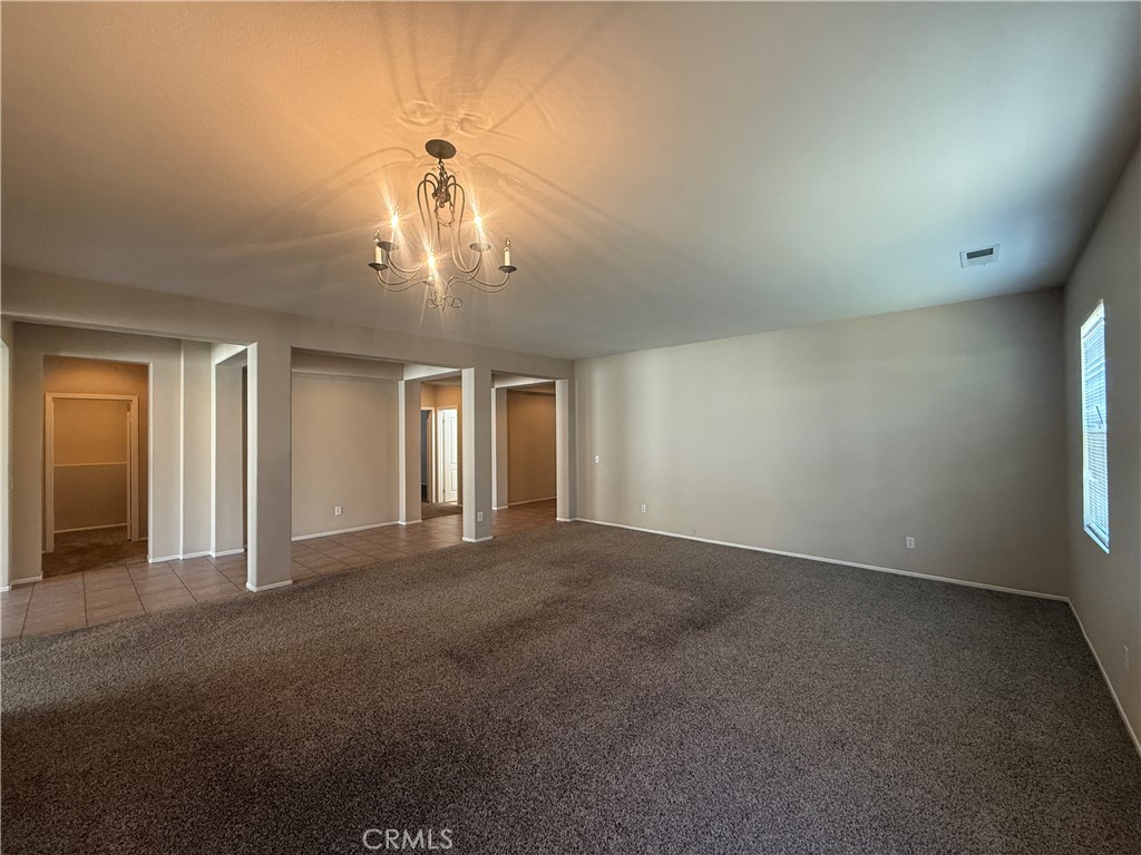 3518 Ranch Street Perris, CA 92571 - Photo 23 of 66 an empty room with a chandelier fan and windows