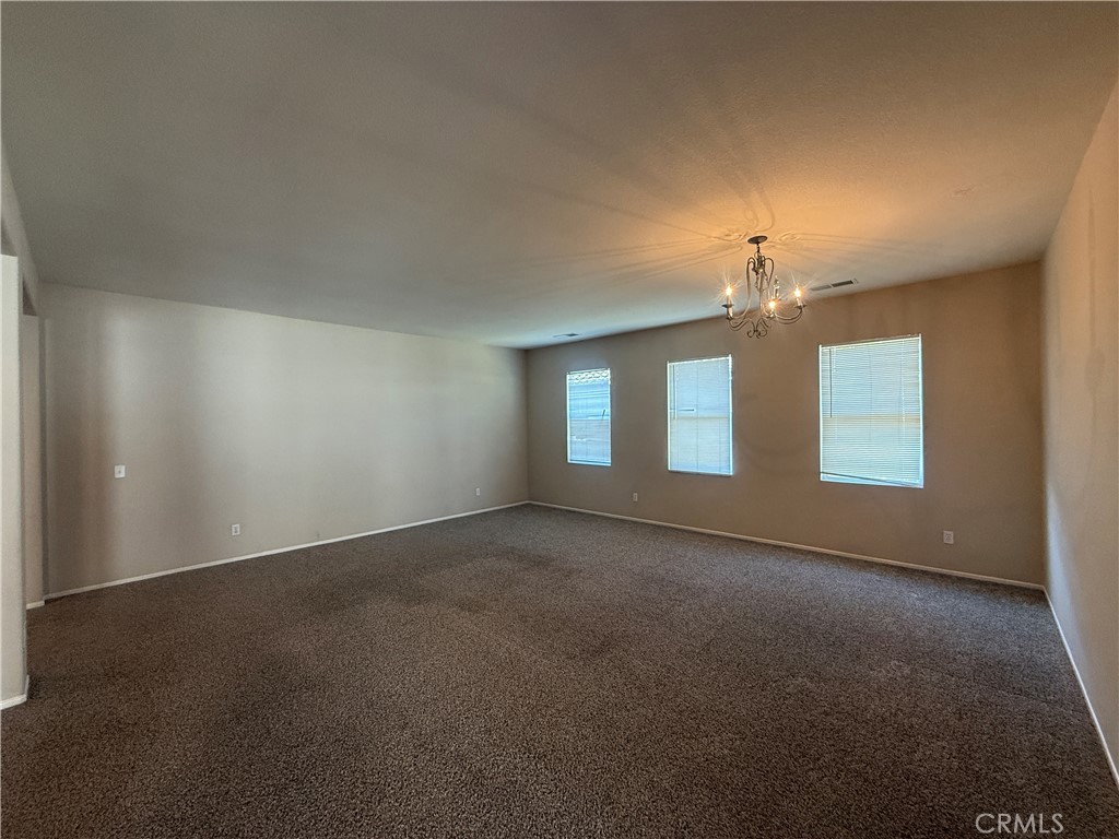 3518 Ranch Street Perris, CA 92571 - Photo 24 of 66 an empty room with a chandelier fan and windows