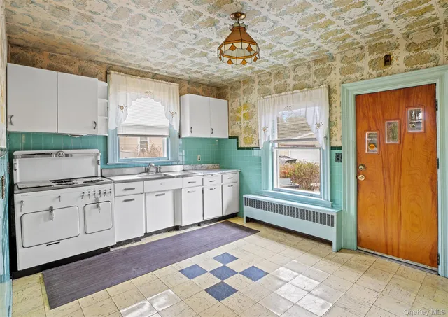 a kitchen with granite countertop a sink cabinets stainless steel appliances and a window