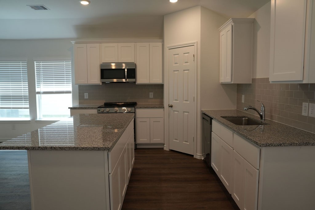 807 Stoney Point Lane Dayton, TX 77535 - Photo 4 of 19 a kitchen with stainless steel appliances granite countertop a sink stove and refrigerator
