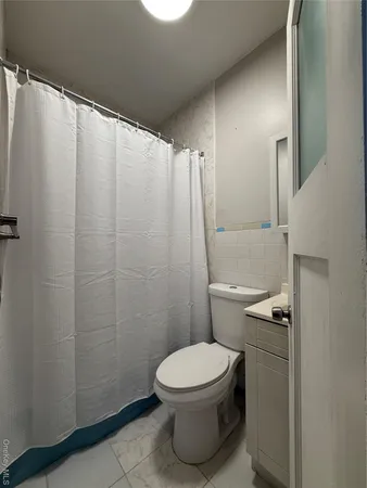 a white toilet sitting next to a shower curtain