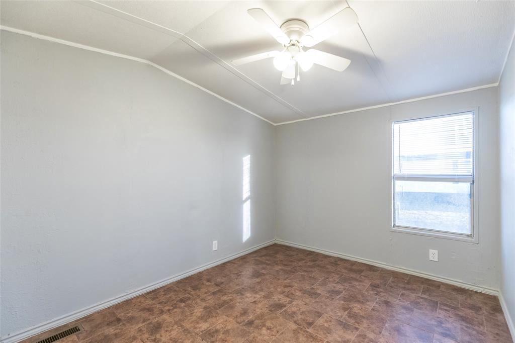 709 Gibson Street Tye, TX 79603 - Photo 11 of 26 an empty room with a chandelier fan and windows