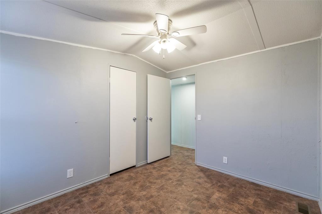 709 Gibson Street Tye, TX 79603 - Photo 12 of 26 an empty room with a ceiling fan and kitchen view