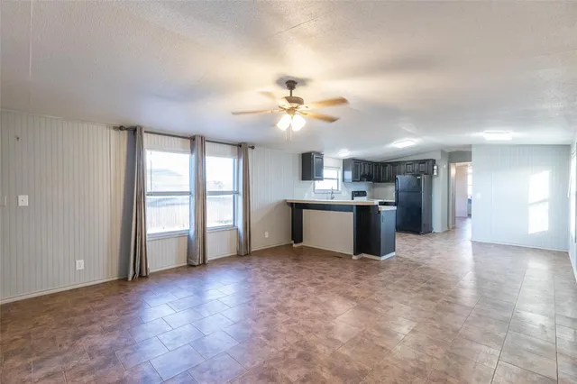 a view of a kitchen with a stove cabinets a ceiling fan and wooden floor