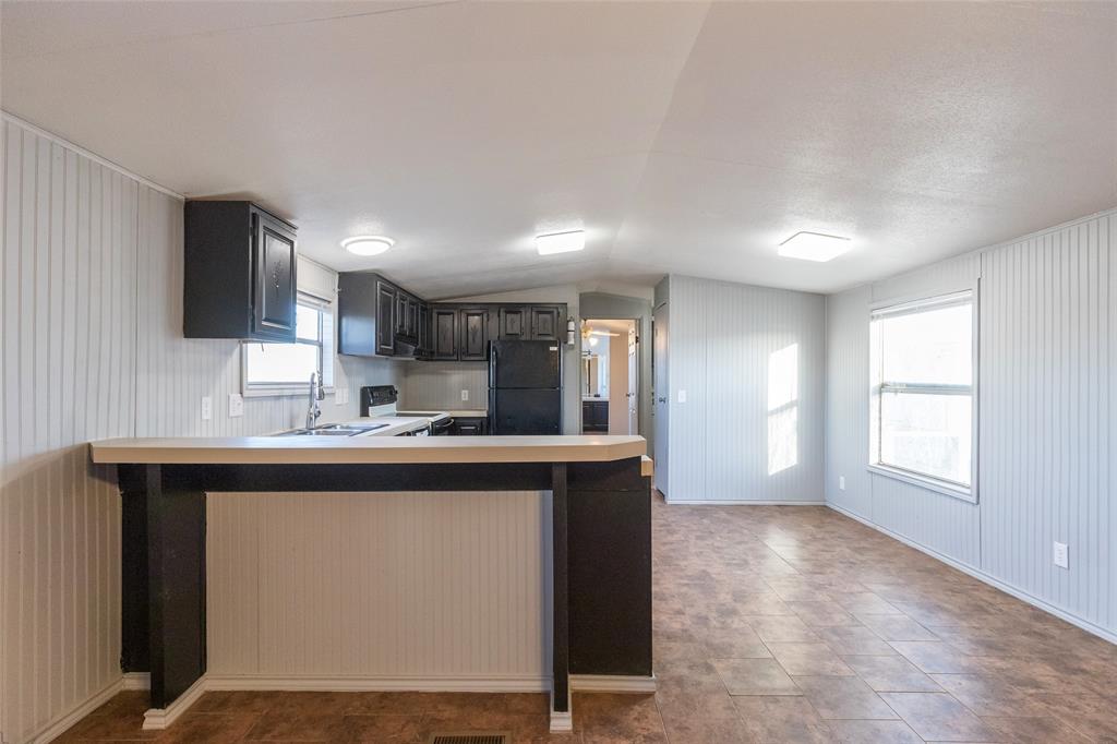 709 Gibson Street Tye, TX 79603 - Photo 15 of 26 a kitchen with kitchen island a sink appliances and cabinets