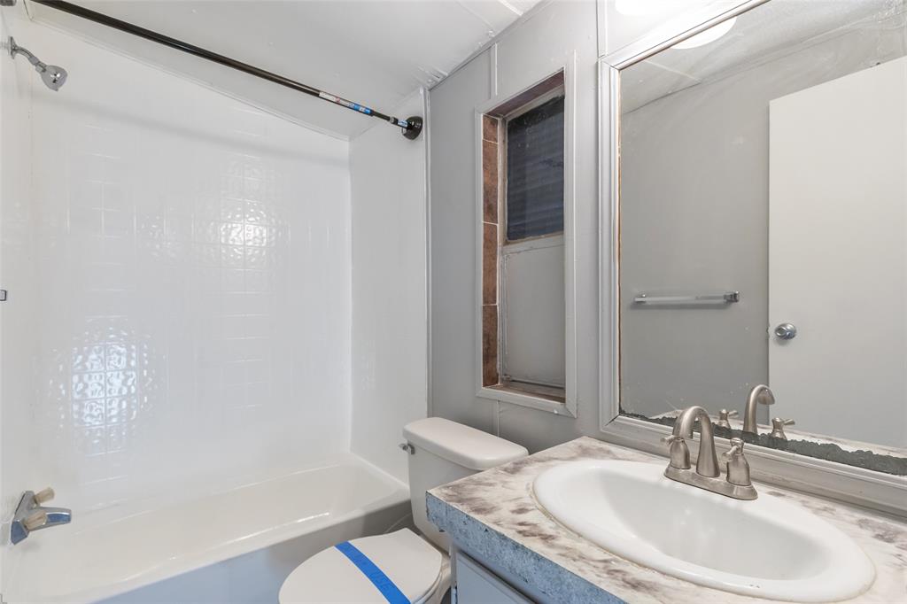 709 Gibson Street Tye, TX 79603 - Photo 7 of 26 a bathroom with a granite countertop sink a toilet and shower