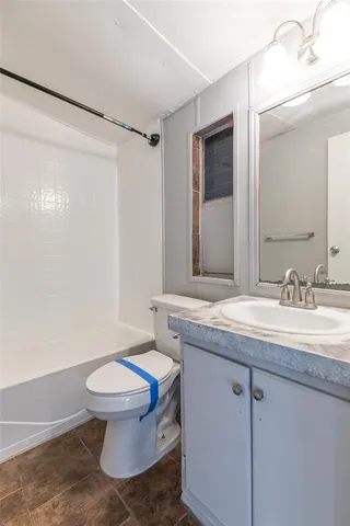 a bathroom with a granite countertop sink a toilet a mirror and shower