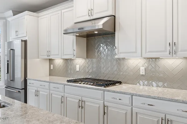 a kitchen with granite countertop white cabinets and stainless steel appliances