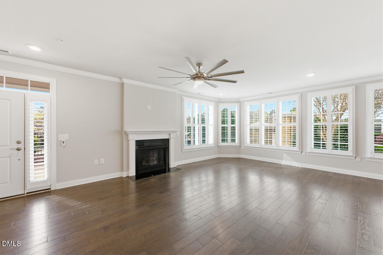 10210 Sablewood Drive, Unit 114 Raleigh, NC 27617 - Photo 13 of 28 a view of an empty room with wooden floor and a fireplace