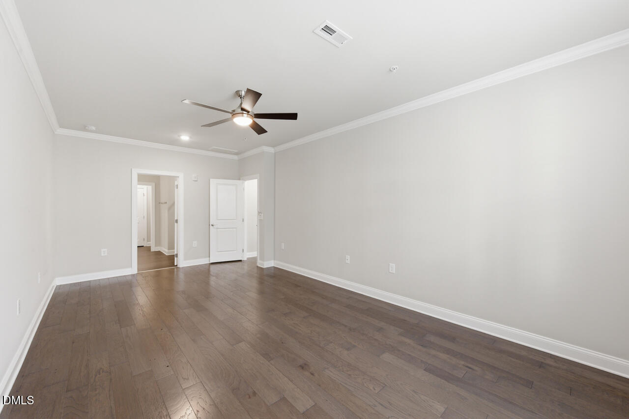 10210 Sablewood Drive, Unit 114 Raleigh, NC 27617 - Photo 18 of 28 an empty room with wooden floor and ceiling fan