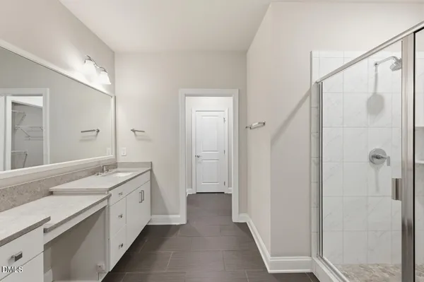 a spacious bathroom with a granite countertop sink a mirror and a shower
