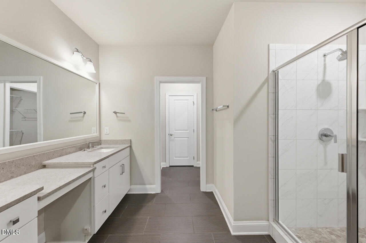 10210 Sablewood Drive, Unit 114 Raleigh, NC 27617 - Photo 19 of 28 a spacious bathroom with a granite countertop sink a mirror and a shower