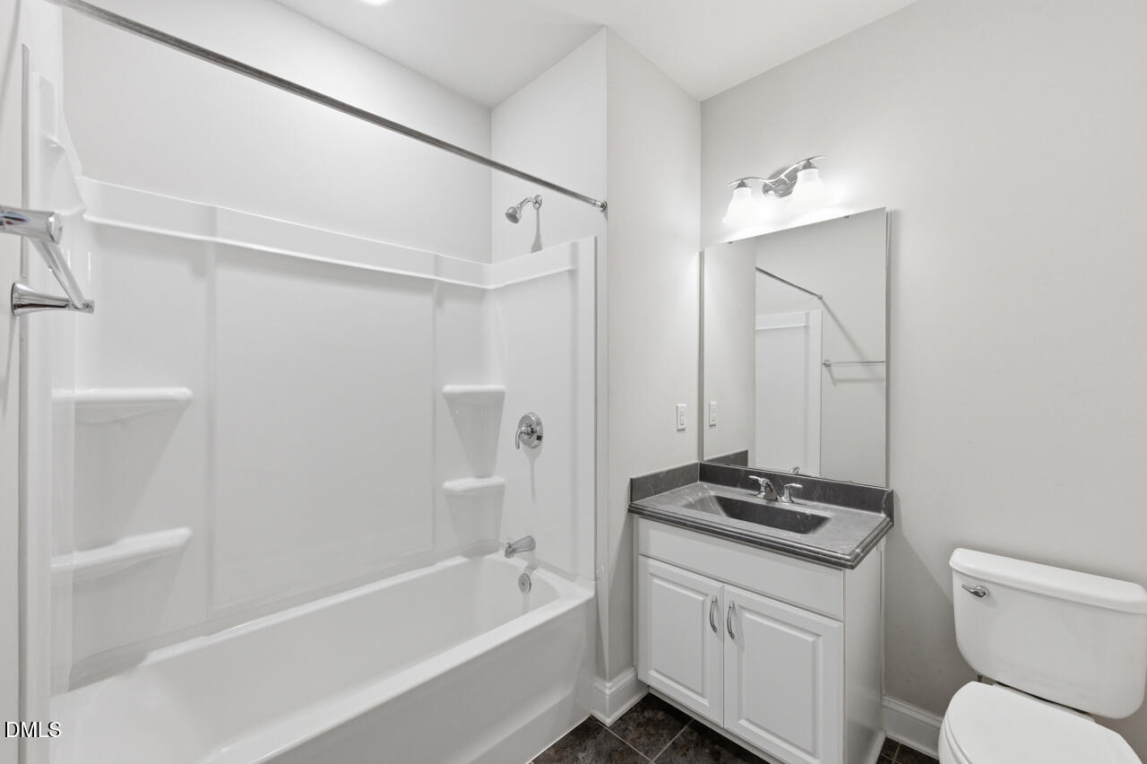 10210 Sablewood Drive, Unit 114 Raleigh, NC 27617 - Photo 24 of 28 a bathroom with a granite countertop sink toilet and shower