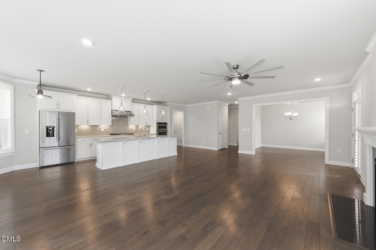 10210 Sablewood Drive, Unit 114 Raleigh, NC 27617 - Photo 5 of 28 a view of an empty room with wooden floor and a kitchen