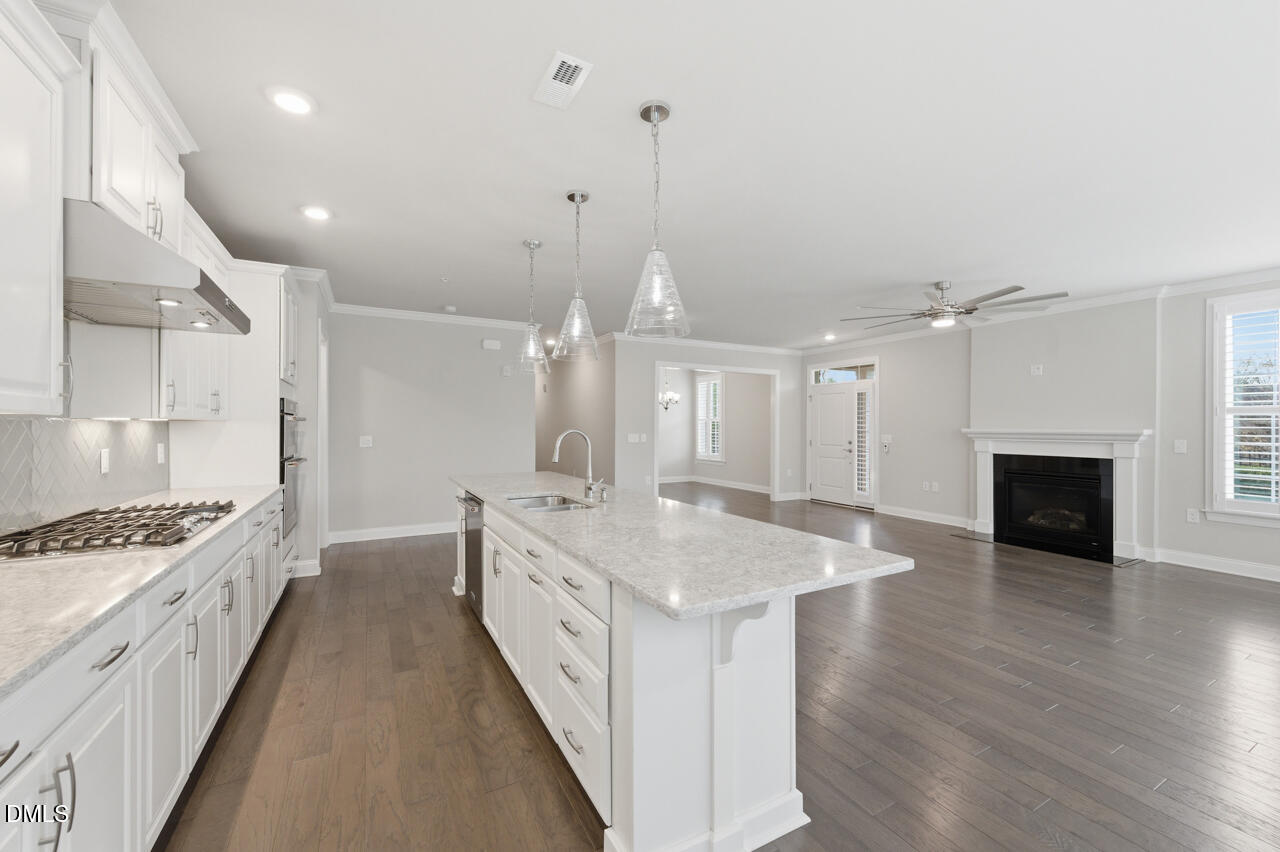 10210 Sablewood Drive, Unit 114 Raleigh, NC 27617 - Photo 8 of 28 a large white kitchen with a stove a sink a refrigerator and a fireplace