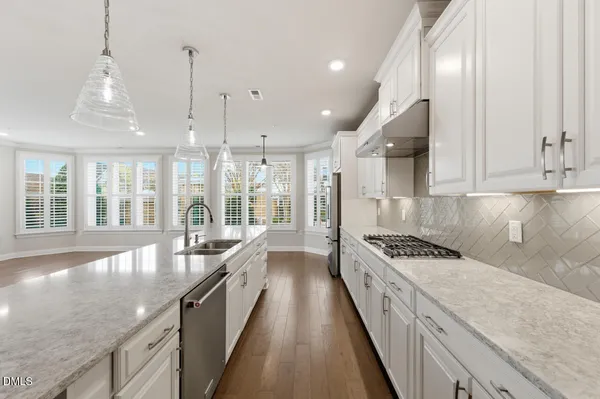 a large kitchen with kitchen island lots of counter space wooden floor and stainless steel appliances