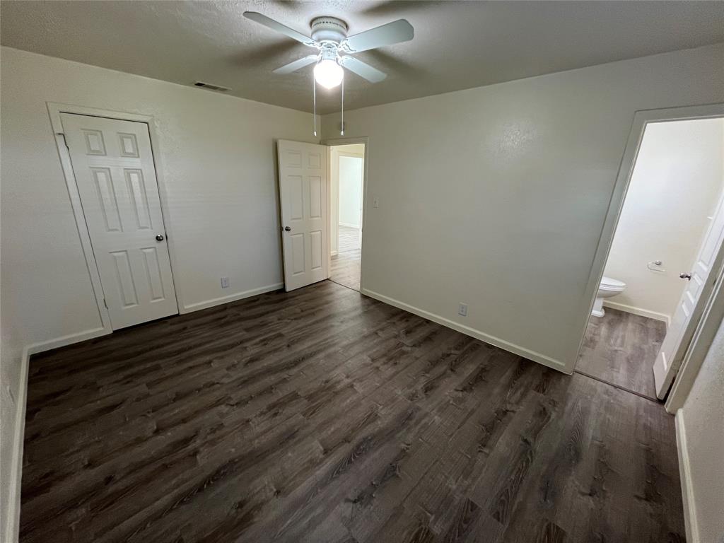 10135 Kittyhawk Lane Dallas, TX 75217 - Photo 8 of 17 Unfurnished bedroom with dark wood-style floors and a ceiling fan