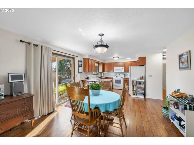 a dining room filled chandelier and wooden floor