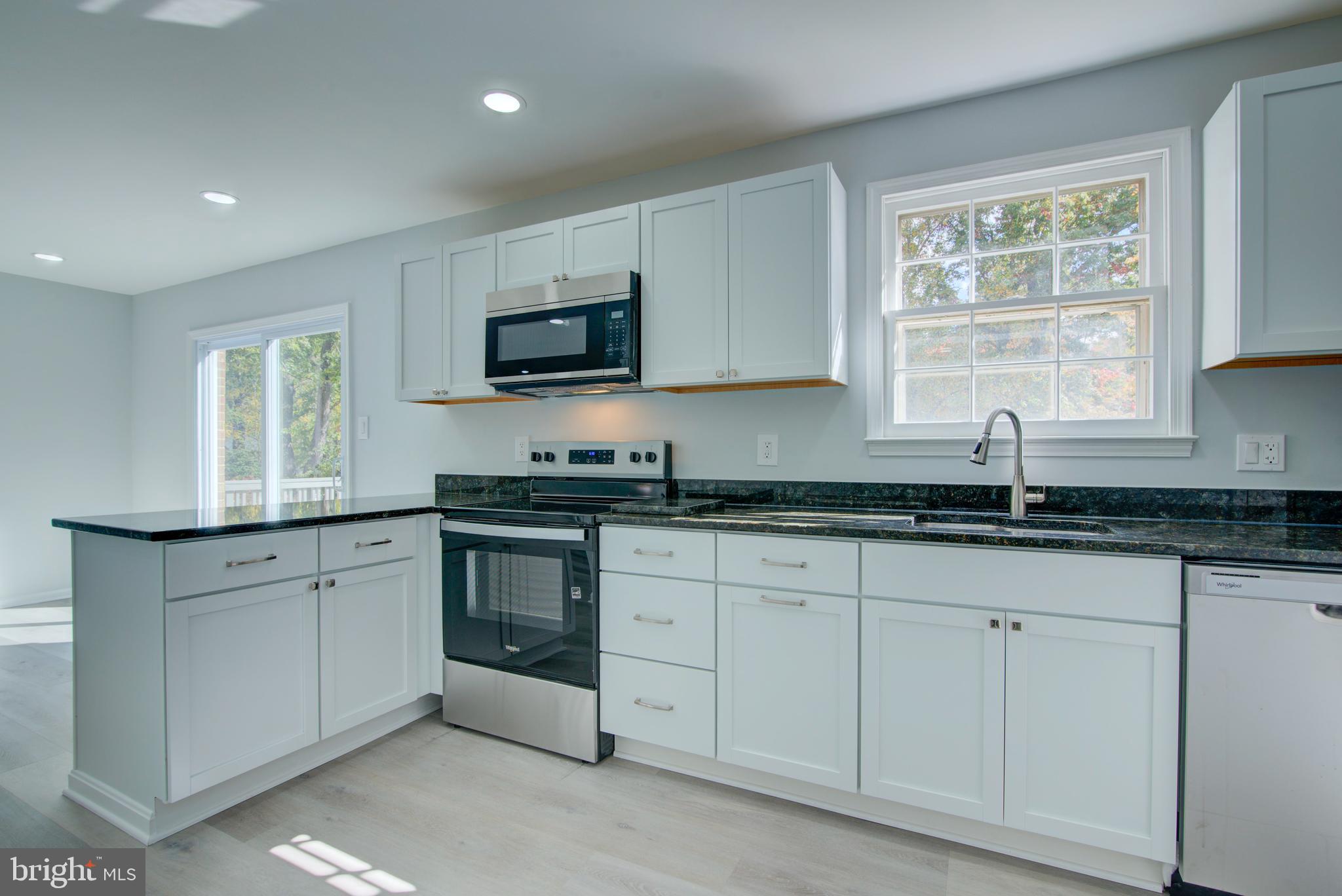 7411 Reservation Drive Springfield, VA 22153 - Photo 2 of 30 a kitchen with granite countertop white cabinets sink and window