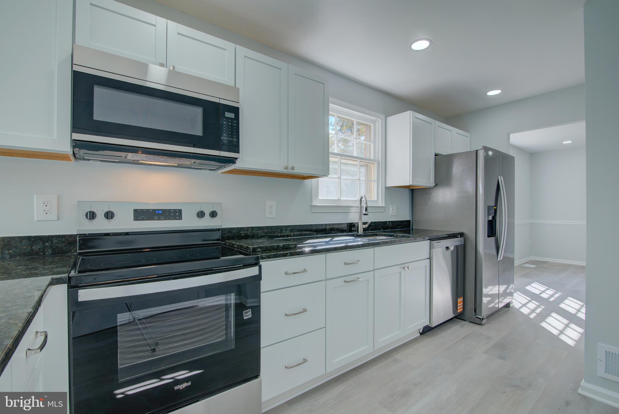 7411 Reservation Drive Springfield, VA 22153 - Photo 4 of 30 a kitchen with stainless steel appliances granite countertop a stove microwave and refrigerator