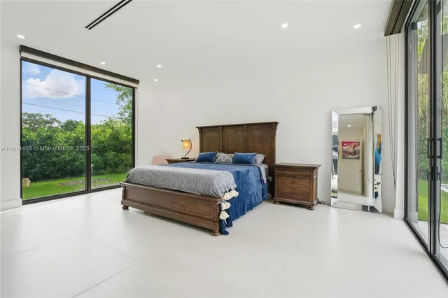 a bedroom with a bed and a large window