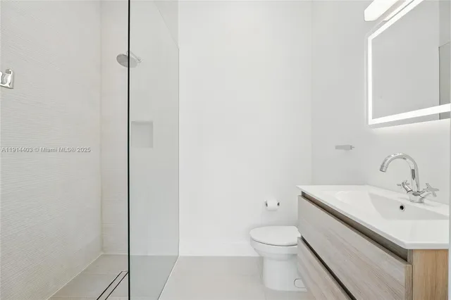 a bathroom with a granite countertop sink a toilet and a shower