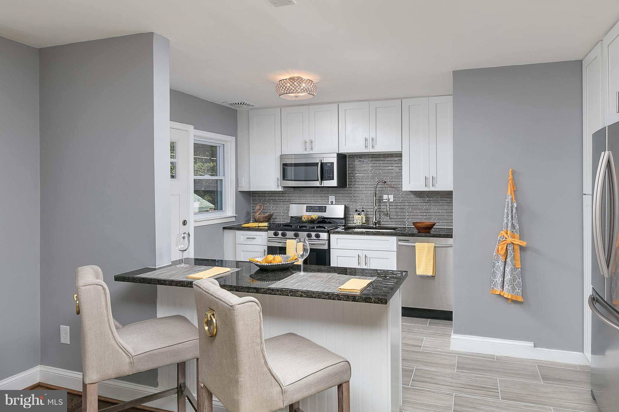 707 Stamford Road Baltimore, MD 21229 - Photo 3 of 30 a kitchen with a dining table chairs and a refrigerator