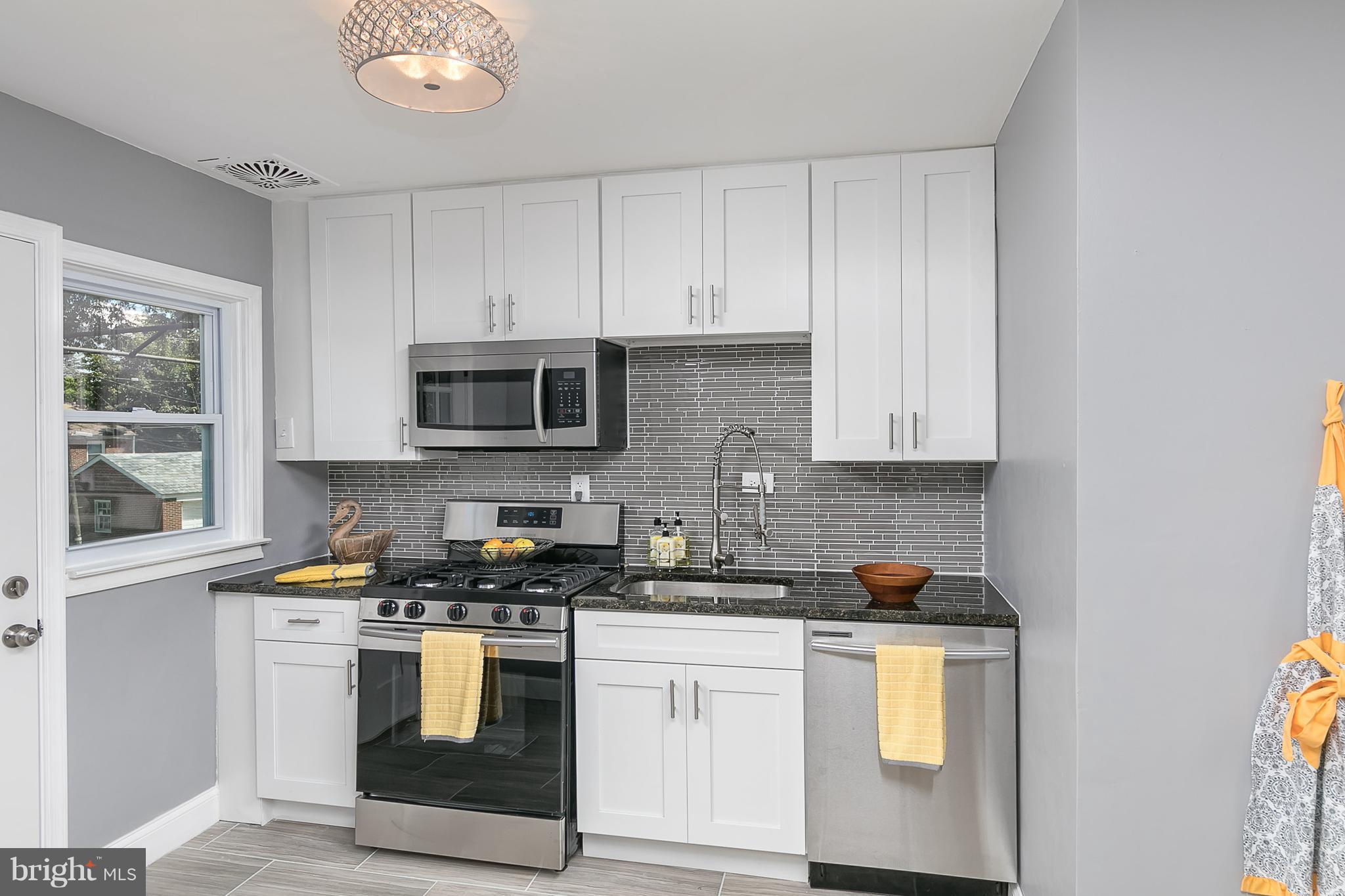 707 Stamford Road Baltimore, MD 21229 - Photo 4 of 30 a kitchen with stainless steel appliances granite countertop a stove a sink and a microwave