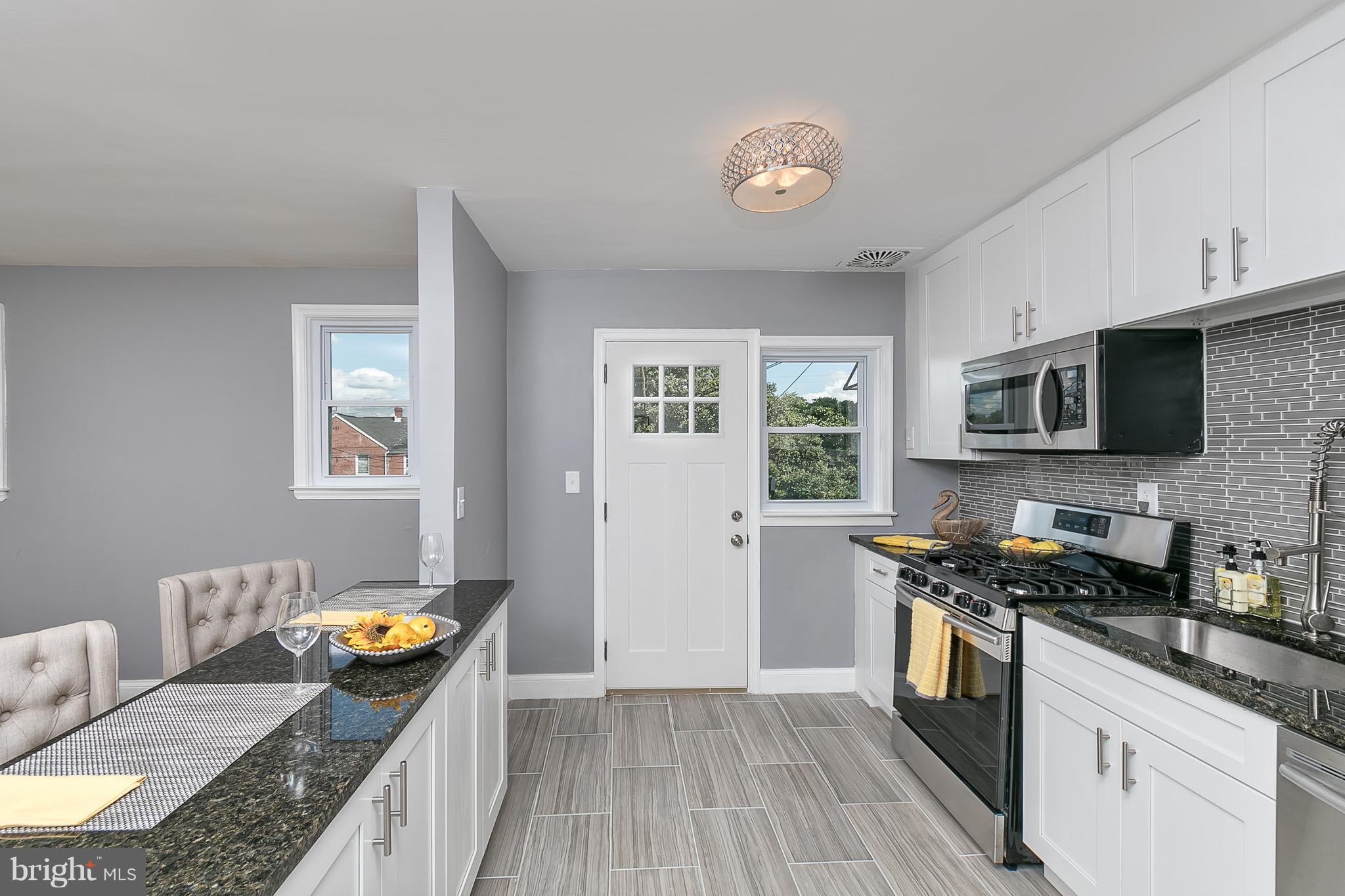 707 Stamford Road Baltimore, MD 21229 - Photo 5 of 30 a kitchen with stainless steel appliances granite countertop a stove a sink and a microwave
