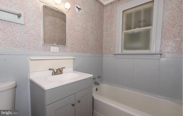 a bathroom with a sink toilet vanity and bathtub
