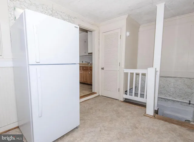 a view of a refrigerator in kitchen and a glass door