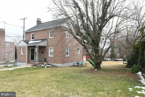 a front view of house with yard and trees around