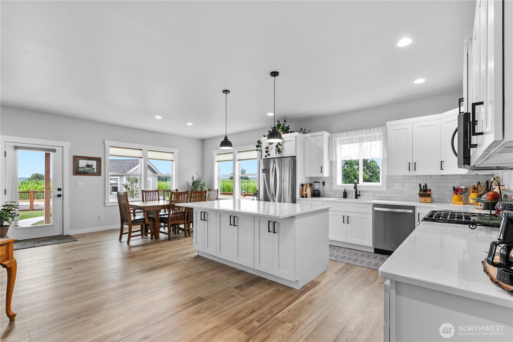 2068 Bowfin Way Lynden, WA 98264 - Photo 5 of 35 a kitchen with white cabinets and wooden floors