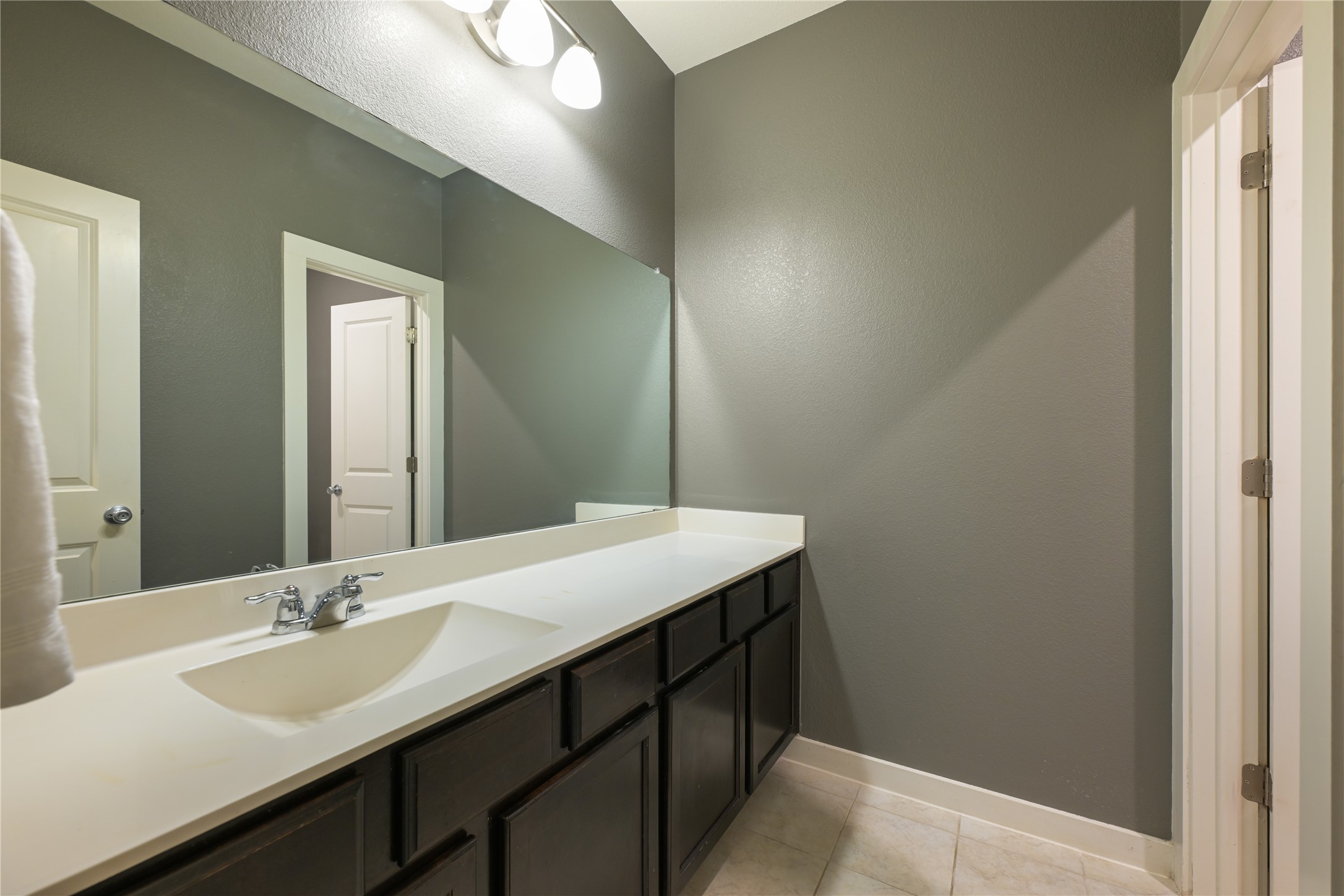 188 Nautical Loop Kyle, TX 78640 - Photo 27 of 38 A well-lit vanity with ample counter space and dark wood cabinetry offers functional elegance.