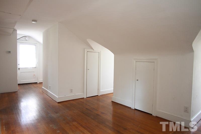 810 Chamberlain Street Raleigh, NC 27607 - Photo 12 of 16 an empty room with wooden floor & windows